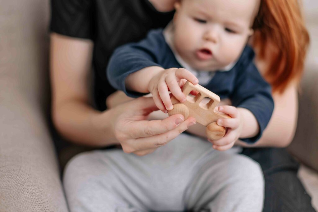 Baby mit Holzspielzeug